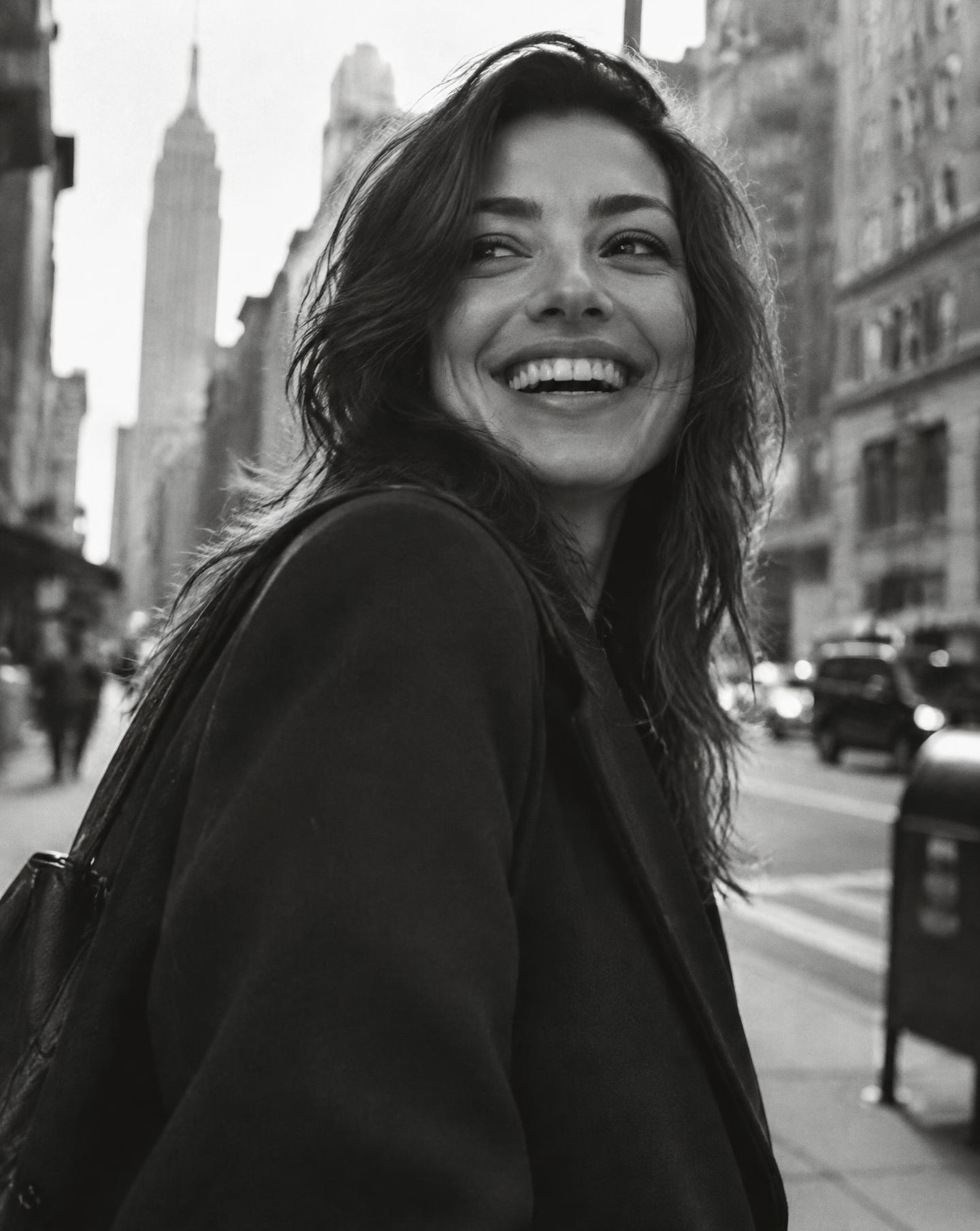 A confident young professional laughing on a city street